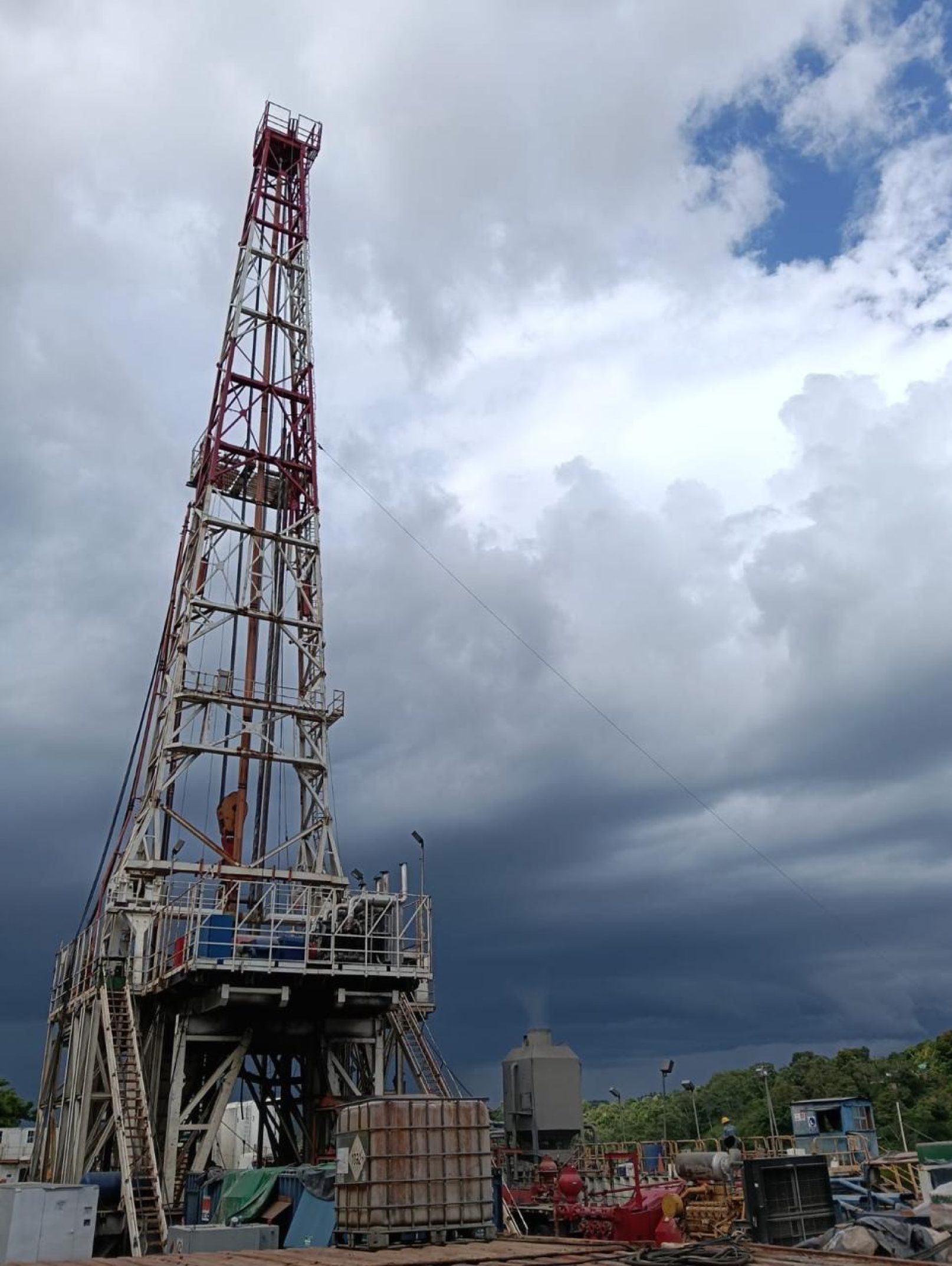 Drilling rig mast against a cloudy sky