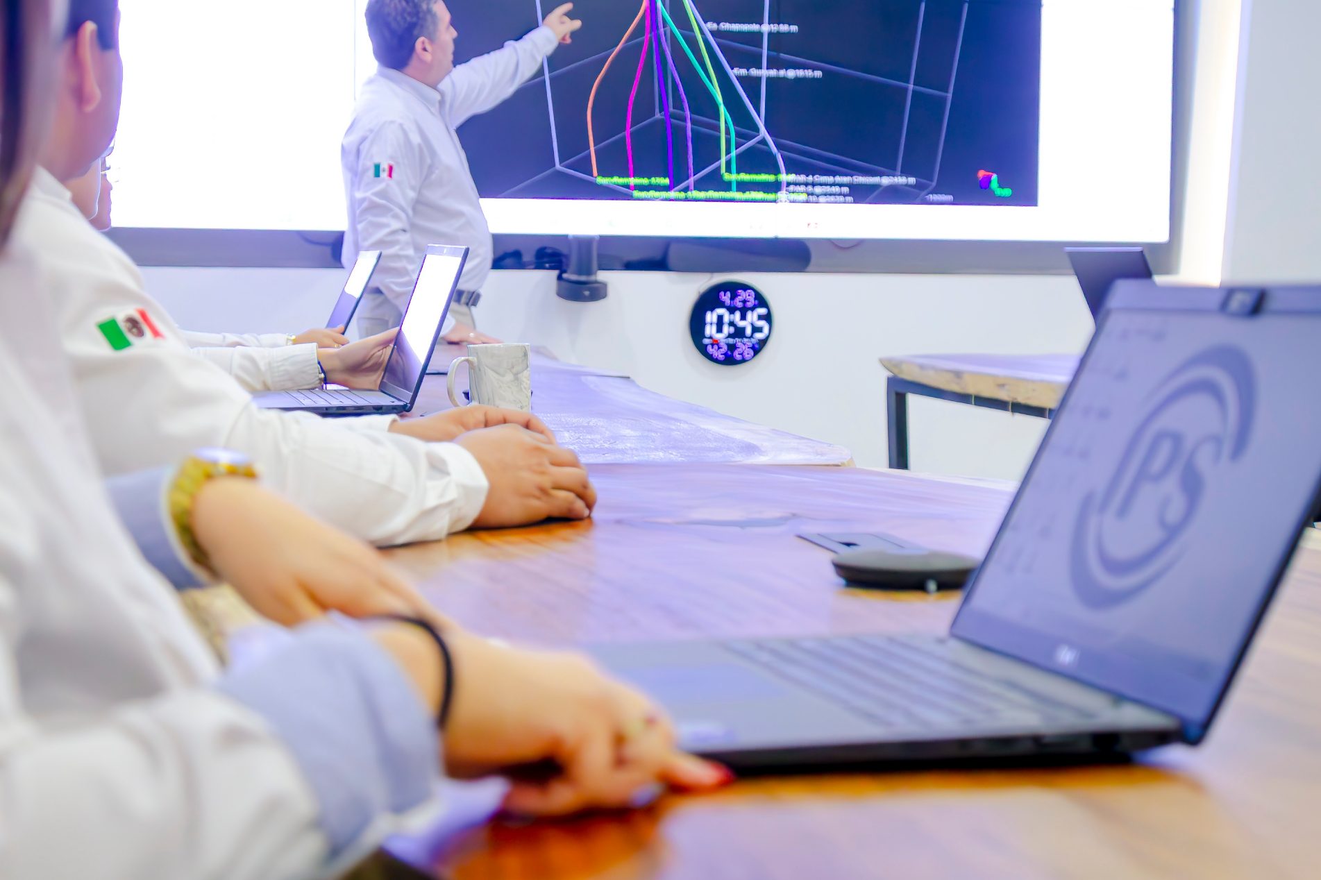 Engineers reviewing a well trajectory model on a large screen