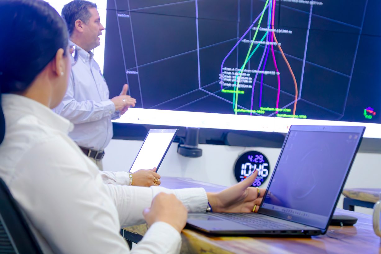 Engineers reviewing a well trajectory on a wall screen